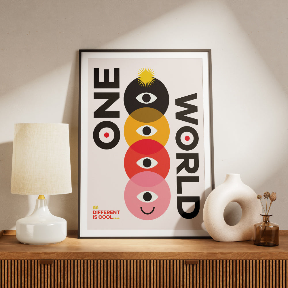 Poster con il testo 'One World' accompagnato da un design geometrico colorato con cerchi sovrapposti in nero, giallo, rosso e rosa, ciascuno contenente un occhio stilizzato e un volto sorridente nell'ultimo cerchio. In basso a sinistra la scritta 'Different is Cool'. Design moderno e simbolico su sfondo chiaro.